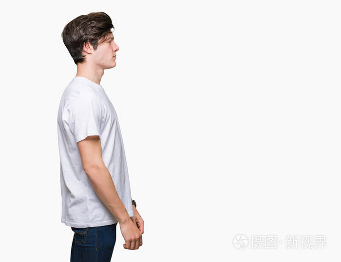 年轻英俊的男人穿着休闲的白色t恤,在孤立的背景下,看着侧面放松的