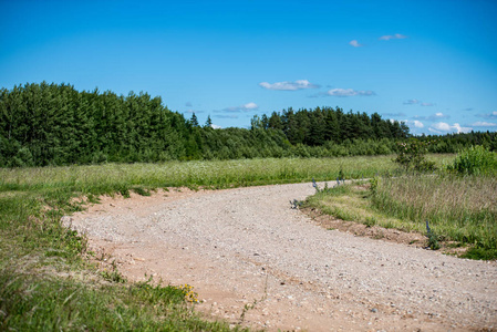空的乡村砾石路,有泥坑和颠簸. 有沙子和小石头的肮脏路面照片