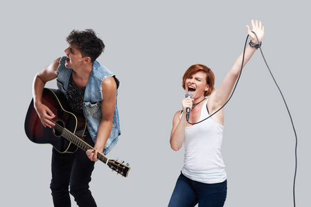 音乐艺术家唱歌和弹声吉他. 当代封面乐队. 孤立在灰色背景上.