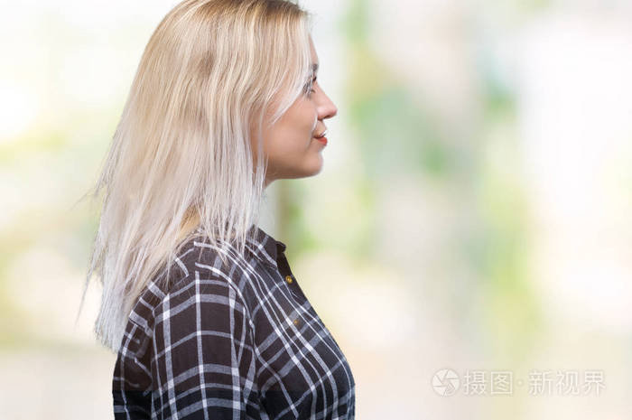 年轻的金发女人在孤立的背景下,看着侧面放松的轮廓姿势,自然的脸