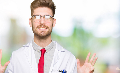 年轻英俊的科学家，戴着眼镜的男人，用手指举着九号，微笑着自信和快乐。