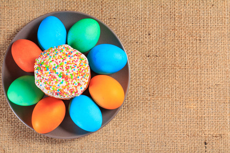 复活节蛋糕和彩绘鸡蛋在盘子上，背景上有麻布。 传统正统基督教复活节食物。 上面的风景。