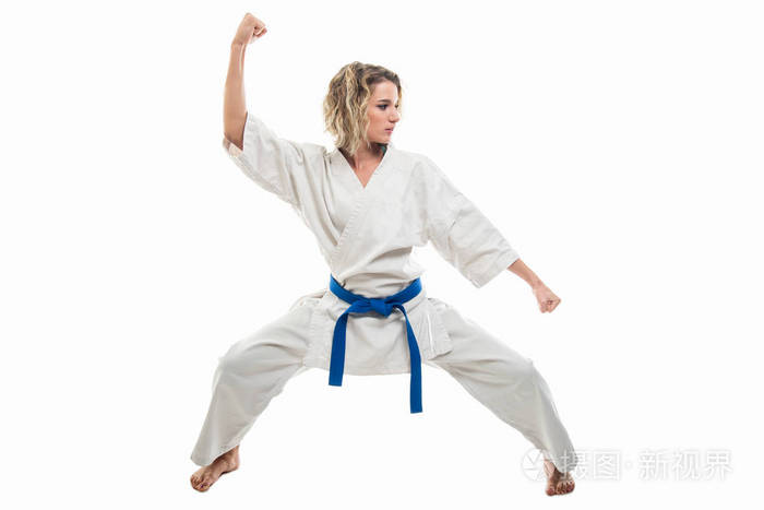穿着白色衣服的女人全身摆着武术姿势,在白色的背景下被隔离