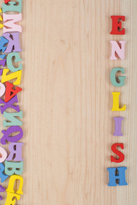 木制背景上的英文单词由五颜六色的ABC字母组成，木制字母，复制空间为广告文本。学习英语