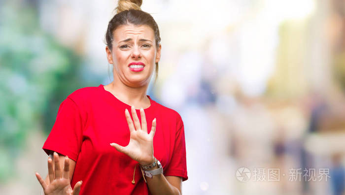 年轻的美女在孤立的背景下,厌恶的表情,不高兴和恐惧