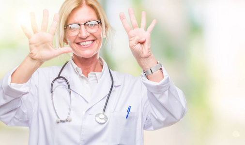 中年金发医生女人在孤立的背景上显示和指着第九个手指，同时微笑自信和快乐。
