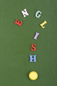 绿色背景上的英文单词，由彩色ABC字母组成，木制字母，复制空间为广告文本。 学习英语
