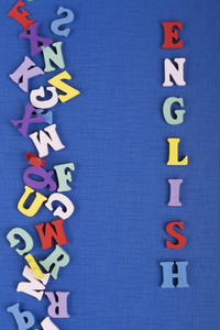 英语单词在蓝色背景上由彩色ABC字母组成，木制字母，复制空间为广告文本。 学习英语