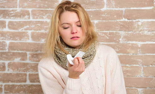生病的女人在餐巾纸上吹鼻子.漂亮的女孩打喷嚏季节性流感病毒.