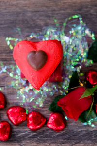 心形的巧克力糖果，上面有红色的包装纸和红玫瑰