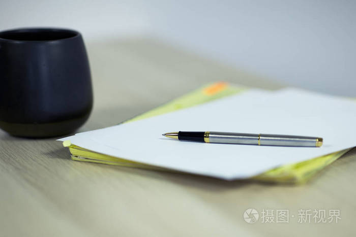 杯咖啡或茶,纸和笔在轻木桌背景上,关闭复制空间