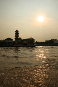 泰国曼谷潮弗里亚河上一座传统宝塔建筑的轮廓与橙色日落相映。