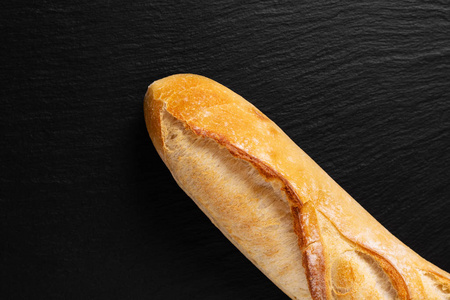 背景食品演示，法国面包在黑色石板板与复制空间。