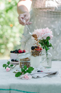 s hands as she eats healthy breakfast .Yogurt with strawberries 