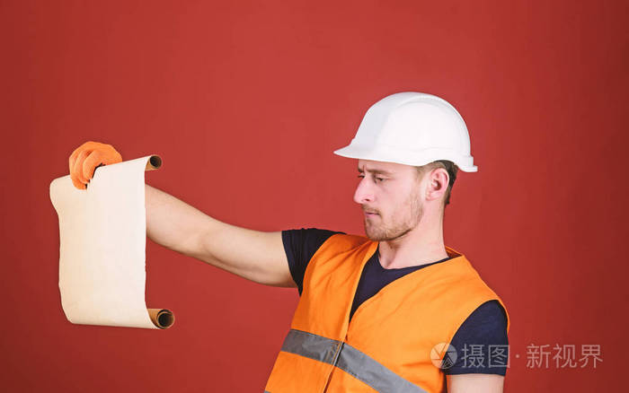 工程师,建筑师,建筑工人在严格的面子上掌握了旧图纸, 监督施工现场.