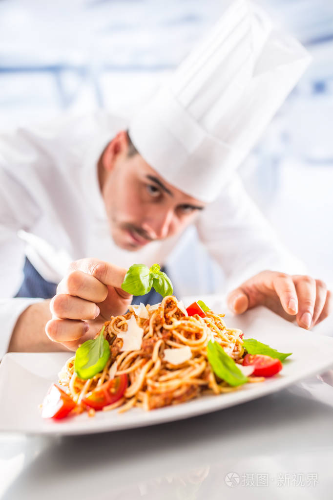餐厅厨房的厨师用手准备和装饰饭菜. 厨师准备意大利面条.