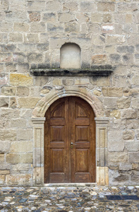 纹理图案。 背景旧米色墙，由天然石材制成，带有门