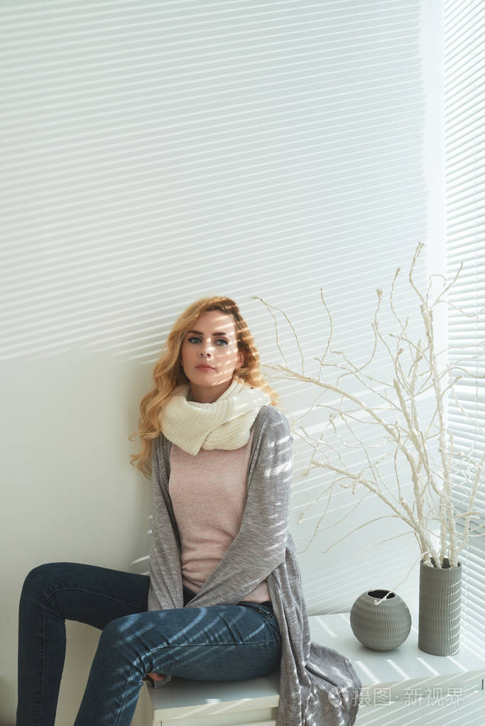忧郁的年轻女子,穿着舒适温暖的衣服在家休息