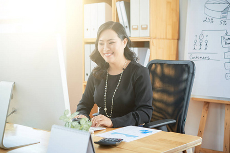 微笑的女商务主管在办公室工作电脑