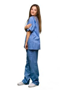 年轻的护士在孤独的背景下微笑着望着肩膀