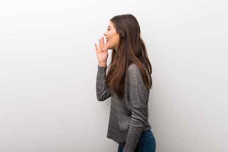 年轻女孩在孤立的白色背脊上大声喊叫,嘴巴向侧面张开摄影图