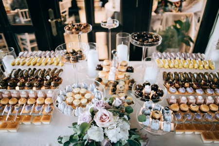 装饰精美的婚礼甜点桌上有蛋糕橡皮泥和其他糖果