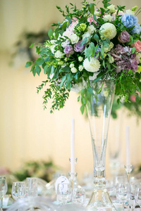 豪华的花放在高花瓶上的桌子上，活动聚会或婚宴。