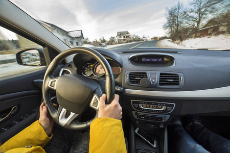 现代汽车内饰与司机女性手在方向盘冬季雪景外。 安全驾驶概念。