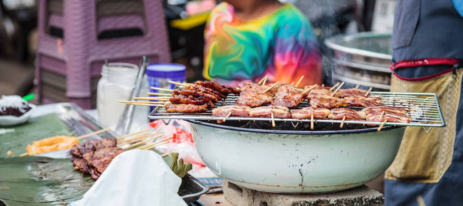 传统的街头美食泰国腌制猪肉串莫平烧烤猪肉串用竹棒烤，经常用糯米饭吃。 泰国美食旅游美食概念。