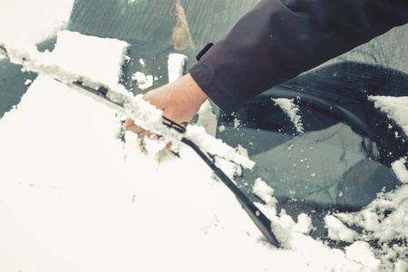 下雪后司机打扫他的车