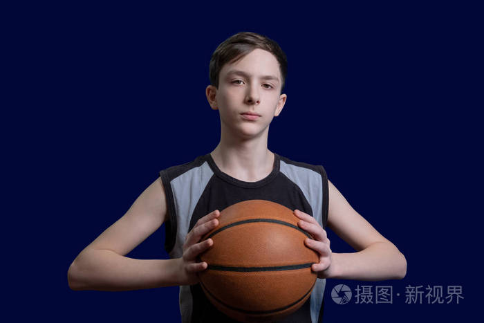 照片 青少年篮球运动员的肖像. 穿黑色t恤的人手里拿着球.