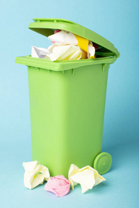 回收箱在蓝色背景上装满纸。 报纸。 废物回收。 生态概念。