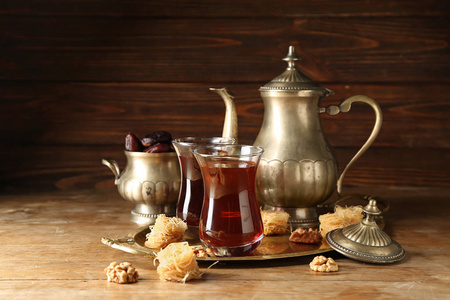木制桌子上有美味的土耳其茶和糖果的构图