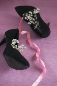 s black velvet shoes with white flowers on pink background vert