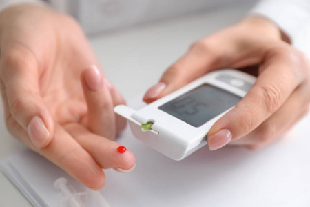 糖尿病妇女使用数字血糖仪特写