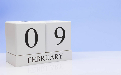 2月9日月09日，每日日历上白色桌面上有反光，有浅蓝色背景..冬天的时间，空的文字空间