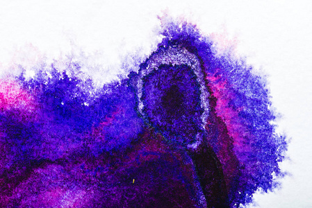 紫色和蓝色水彩溢出在白纸上的顶部视图。