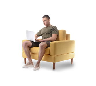 年轻男子手提电脑坐在扶手椅上，背景是白色的