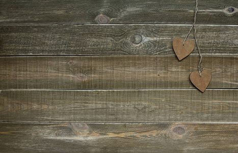 情人节。 2月14日概念。 两个木制的心，用绳子绑在棕色的老式木制背景上。 文本空间。