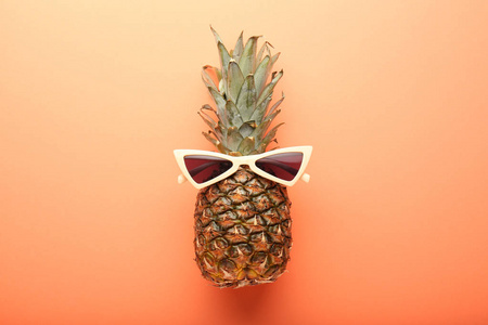 多汁菠萝与时尚太阳镜的颜色背景