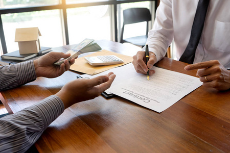 新协议商务人员签订新买房或租房合同的协议,桌上有一个房子模型照片