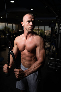 肌肉健身健美运动员在健身房用电缆在机器上对三头肌进行举重锻炼