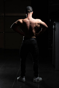 一位身体健康的年轻男子的肖像，展示了他训练有素的身体肌肉运动健美运动员健身模型在锻炼后摆姿势