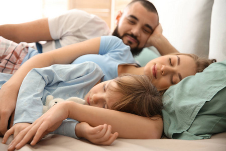 一家睡眠幸福的一家人睡在家里的床上照片