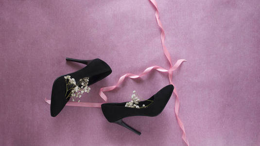 s black velvet shoes with white flowers on pink background hori