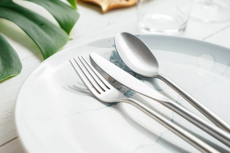 白色桌子上有盘子的银色餐具