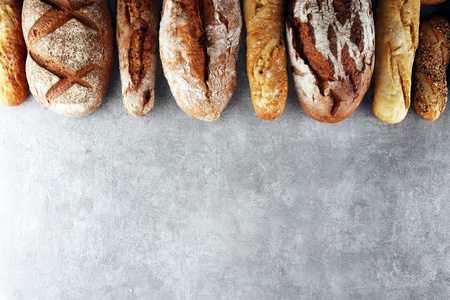 石桌背景上的烘焙面包和面包卷。 面包店海报概念