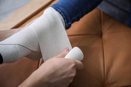 女人用绷带包扎女腿特写照片