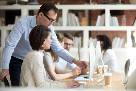 导师主管首席执行官帮助员工解释办公室里的电脑工作照片