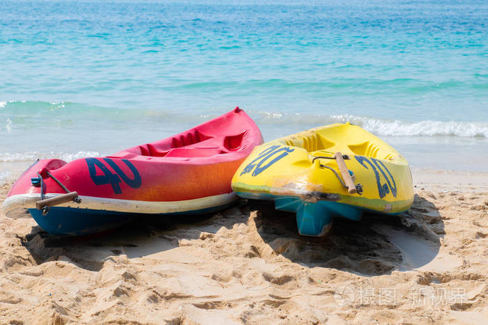 蓝色海面上的独木舟。在阳光明媚的日子里, 海滩上有黄色和蓝色的皮划艇。运动暑期爱好, 激情背景。有一个地方的文字